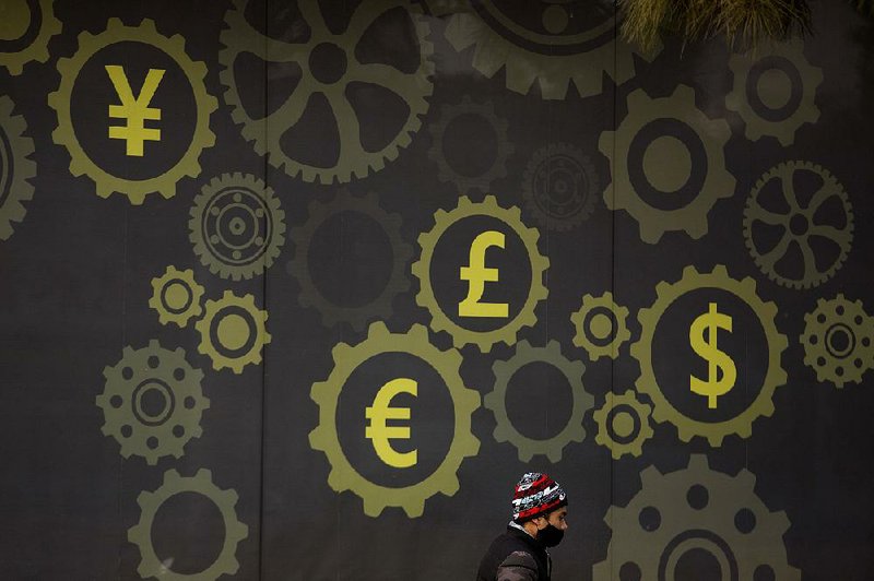 A deliveryman passes a display showing symbols for world currencies on a bank in Beijing last week. Chinese authorities are cracking down on protests after the collapse of Qianbao.com, a financial venture suspected of fraud or mismanagement that cost depositors as much as $4.7 billion. 