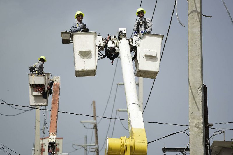 Workers for Puerto Rico’s Electric Power Authority in October repair distribution lines damaged by Hurricane Maria in the Cantera community of San Juan. 