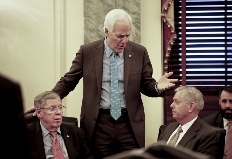 Senate Majority Whip Sen. John Cornyn, R-Texas, center, talks with Sen. Johnny Isakson, R-Ga., left, and Sen. Lindsey Graham, R-S.C., right, before the start of a meeting on immigration Wednesday, Jan. 24, 2018 on Capitol Hill in Washington. (AP Photo/Pablo Martinez Monsivais)