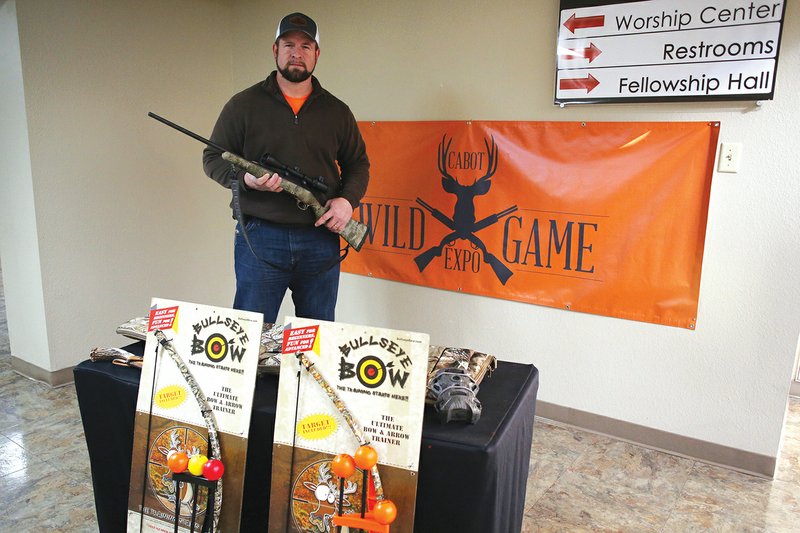Brett Tullos, head of men’s ministries at Mount Carmel Baptist Church, shows off some of the items to be given away at the Cabot Wild Game Expo on Feb. 17.