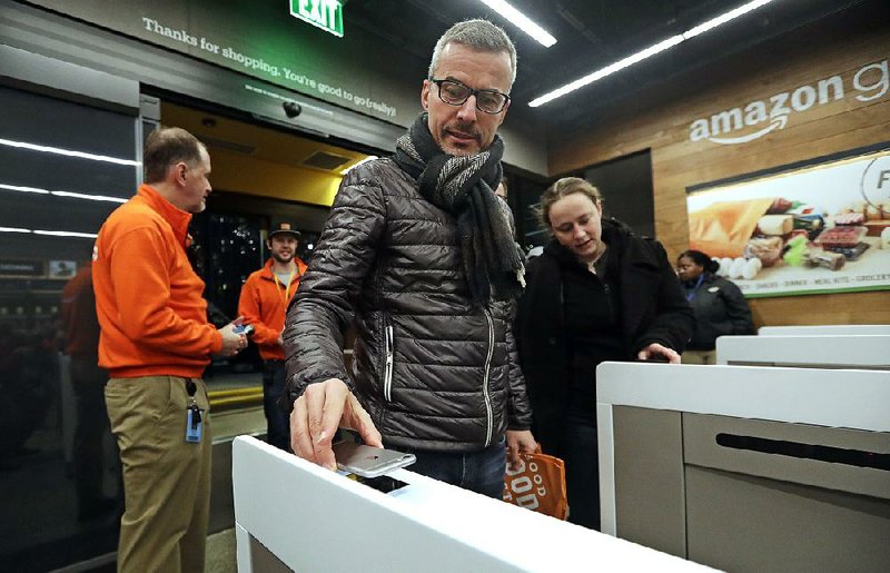A customer scans his Amazon Go cellphone app at the entrance as he heads into the Amazon Go store last week in Seattle. 