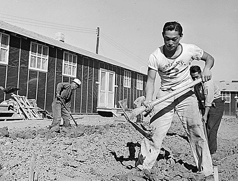 Japanese-American men dig a drainage ditch near barracks at the Rohwer Relocation Center in 1942. Adults in the camps were allowed to work for about the same wages as the lowest-paid Army privates.