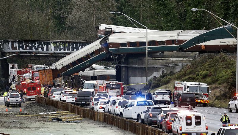 Rail cars from a wrecked Amtrak train are removed in December from a bridge over Interstate 5 near DuPont, Wash. The National Transportation Safety Board released a report on the accident Thursday. 