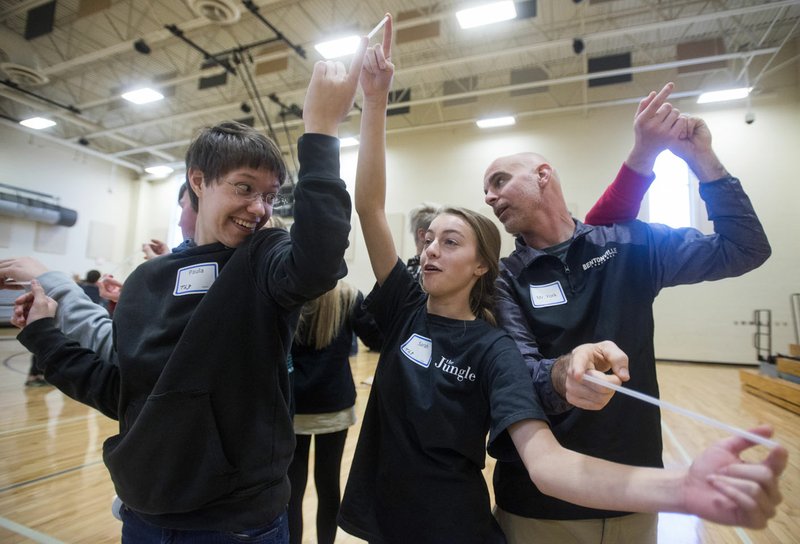 Paula Ryburn (from left) and Sarah Young, both Bentonville High students, and Kevin York, a Bentonville High math teacher and assistant football coach, play a game where the group tries to move without dropping their straws Thursday during a morning of team-building activities as part of a Breaking Down the Walls session at Bentonville High School. Groups of roughly 150 students, faculty and staff from Bentonville High and Bentonville West High participated in the all-day programs this week, which are meant to develop appreciation of diversity and acceptance of others.