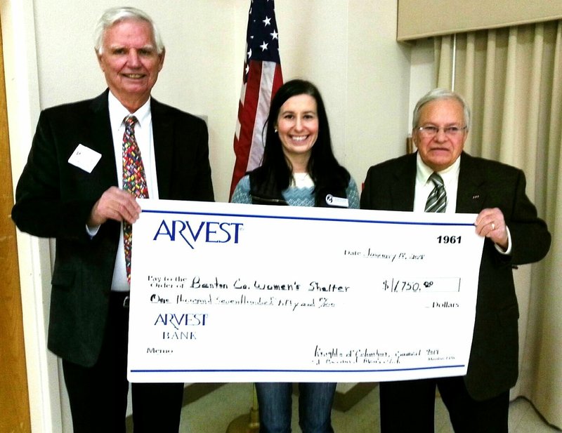 Bob Stewart, president of the Men's Club, and Tom Buchl, Grand Knight of the Knights of Columbus, present a check from bingo proceeds at St. Bernard of Clairvaux Catholic Church in Bella Vista to Amber Lacewell of the Northwest Women's Shelter.