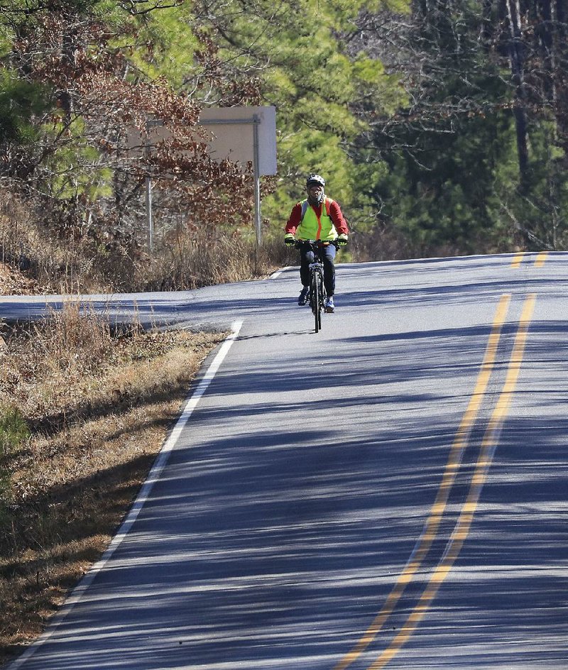 A cyclist rides Friday along Pinnacle Valley Road near the entrance to the Pinnacle Mountain State Park Visitor Center. Arkansas State Parks applied for a grant with Metroplan to fund a pedestrian and bike path at the park.