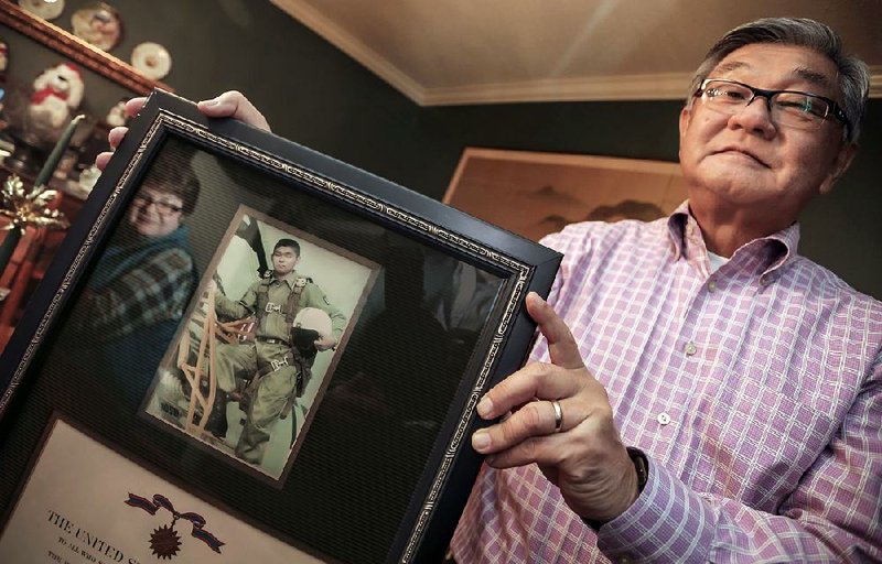 With her husband, Richard Yada, holding the picture frame, Barbara Yada’s reflection smiles beside a vintage photo of Richard taken when he was in the U.S. Air Force.