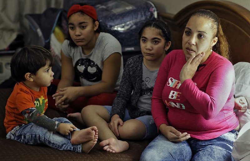 Leslie Rivera (right) sits with her children earlier this month in their hotel room in Tampa, Fla., where they’ve been living since Hurricane Maria destroyed their home in Puerto Rico in September.