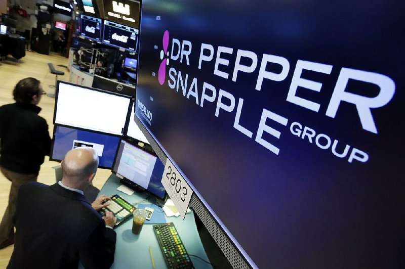 The Dr Pepper Snapple Group logo appears above a trading post at the New York Stock Exchange on Monday. Keurig Green Mountain Inc. plans to buy Dr Pepper Snapple Group Inc.