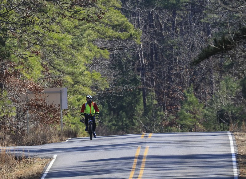 A cyclist rides along Pinnacle Valley Road near the entrance to the Pinnacle Mountain State Park Visitor Center in this January 2018 file photo.