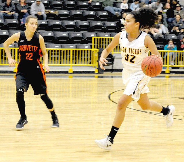 MARK HUMPHREY ENTERPRISE-LEADER Prairie Grove freshman Jasmine Wynos brings the ball up against Gravette senior Tori Foster. Wynos got the ball in the paint and drove for the winning basket with two seconds left as the Lady Tigers upset Gravette, 54-52, on Jan. 23. The 5-9 forward/center scored 6 points making 3 of 4 shots and pulled down 5 rebounds.