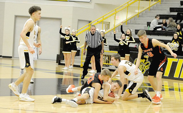 MARK HUMPHREY ENTERPRISE-LEADER/Prairie Grove junior Riley Rhodes protects the basketball from the efforts of Gravette sophomore Brayden Trembly to force a jump-ball. Prairie Grove junior Nick Pohlman and Brayden's older brother, Kelton Trembly, a Gravette senior, are also mixed up in the fray as Prairie Grove senior D.J. Pearson looks to help. Gravette squeaked by the Tigers, 59-57, on Jan. 23.