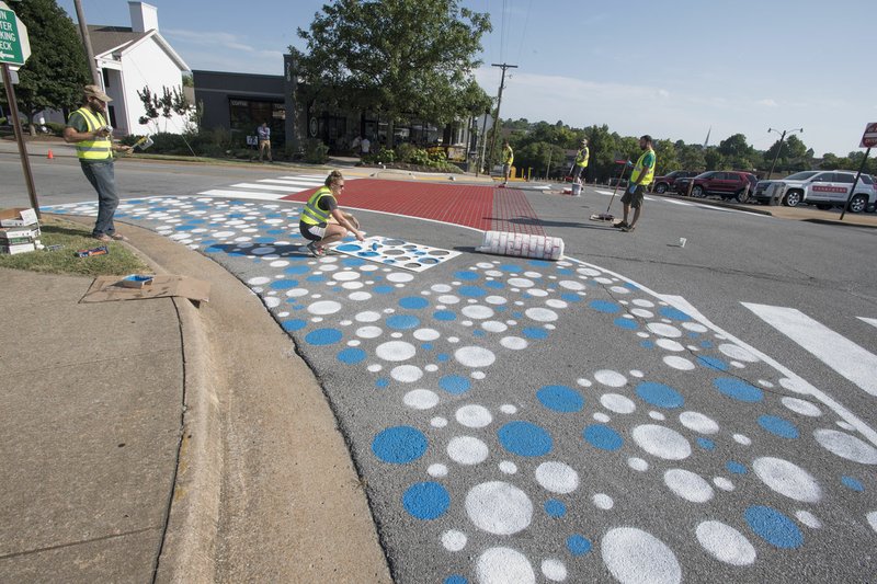 File Photo/NWA Democrat-Gazette/J.T. WAMPLER Volunteers on July 23 paint a crosswalk and curb extensions at Church Avenue and Center Street in Fayetteville as part of the city's tactical urbanism program.