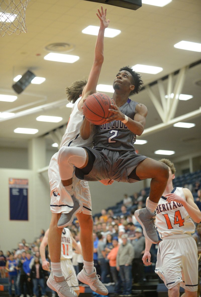 Fayetteville’s Jon Conley (2) goes up and under Rogers Heritage’s Logan Clines (left) on Tuesday at War Eagle Arena in Rogers. Visit nwadg.com/photos for more photos from the game. 