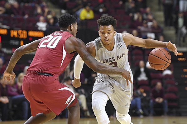 Texas A&M's Admon Gilder (3) tries to keep the ball away from Arkansas' Darious Hall (20) during the first half of an NCAA college basketball game Tuesday, Jan. 30, 2018, in College Station, Texas. (Laura McKenzie/College Station Eagle via AP)

