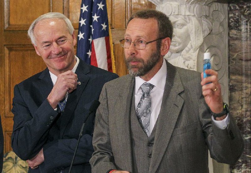 Arkansas Department of Health Director Nate Smith addresses the importance of hand-washing and using hand sanitizer to curtail the spread of flu as he speaks at a Tuesday news conference with Gov. Asa Hutchinson and other state officials. 