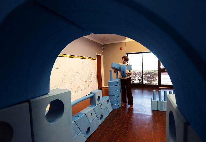 Rachel M. Miller, executive director of the Arts & Science Center for Southeast Arkansas, arranges blue boxes in a children’s play area at the center. The ASC, celebrating its 50th year, offers a wide range of programming for all age groups.