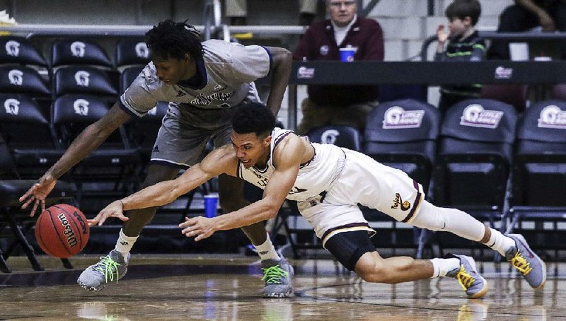 UALR’s Jaizec Lottie (right) and Georgia Southern’s Quan Jackson scramble for a loose ball Thursday at the Jack Stephens Center in Little Rock. The Trojans lost 67-61 and dropped their fifth consecutive game in the Sun Belt Conference. 