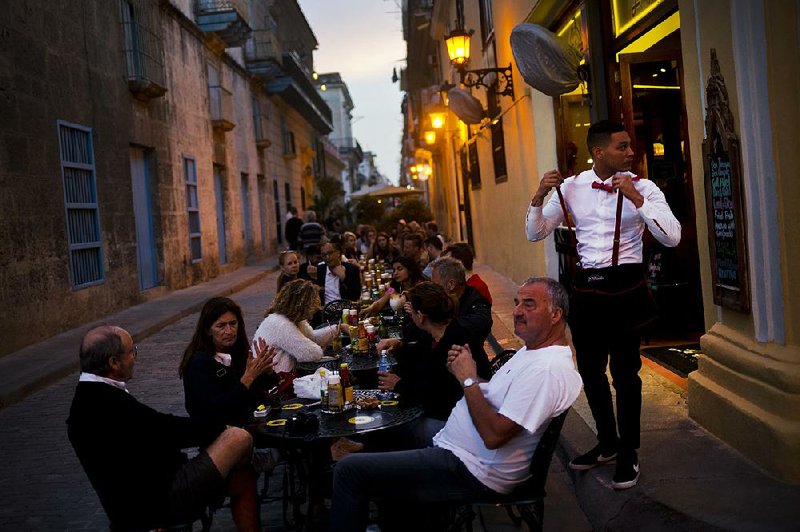 A waiter serves customers Wednesday outside a private restaurant in Havana. Such businesses have flourished in the past two years in Cuba but now their future is in doubt.