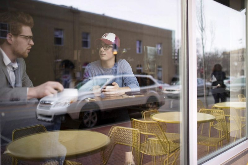 NWA Democrat-Gazette/CHARLIE KAIJO Bradley Morris (left) of Rogers and Denver Smith of Bentonville enjoy coffee Thursday at Onyx Coffee in Bentonville. Downtowns in Northwest Arkansas continue to experience strong population growth and increased demand for residential and commercial development, according to officials.