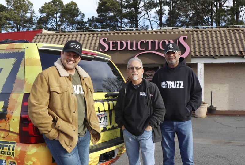 FILE — Morning radio show hosts David Bazzel, Roger Scott and Tommy Smith pose for a photo outside a lingerie shop in Little Rock, Ark., where they hosted their show for KABZ-FM on Feb. 2, 2018. Last year, the shop sponsored the "Babe Bracket" competition, in which listeners cast votes among 16 local female TV personalities. Bazzel said the competition isn't meant to demean women, but to give their work extra exposure. (AP Photo/Kelly P. Kissel)