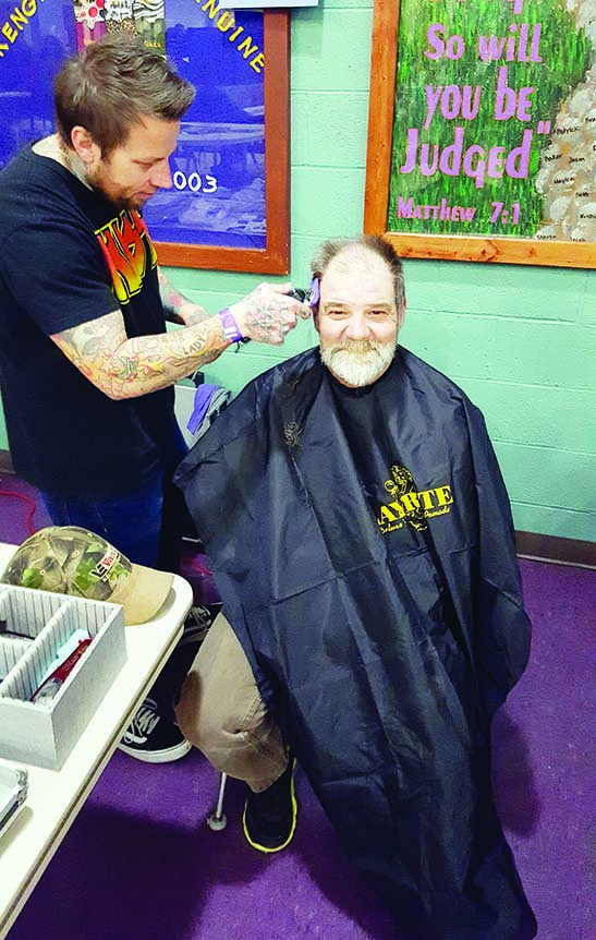 Clayton Keith of Clayton Keith Salon in Little Rock cuts a man’s hair at Project Homeless Connect, which took place Jan. 25 in the St. Joseph Parish Hall in Conway. The one-stop event featured free haircuts, health screenings, pet services, dental visits and more. More than 123 homeless people were served, said Melissa Allen, community programs director for Community Action Program for Central Arkansas, which organized the event.