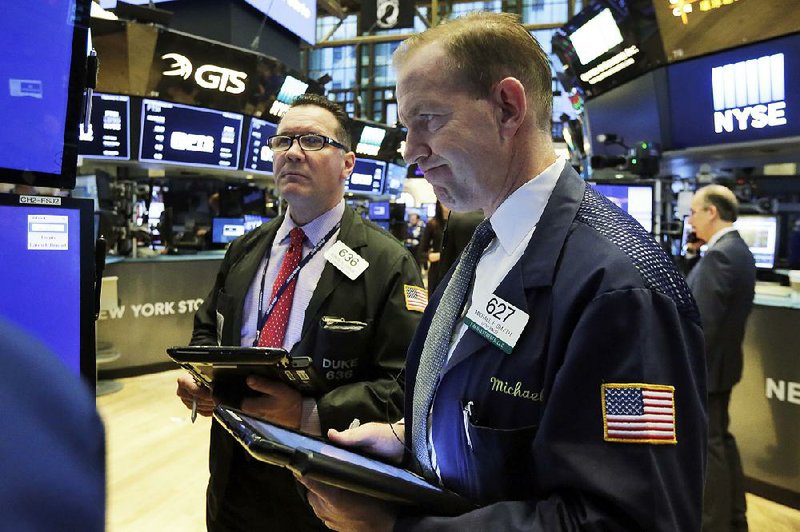 Traders Edward Curran (left) and Michael Smyth watch stocks slide Friday on the floor of the New York Stock Exchange. 