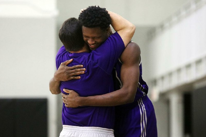 Central Arkansas freshman forward Sikiru Shittu hugs a member of the Bears’ staff during practice this week in Conway. Shittu’s heart stopped during a preseason scrimmage in September. This week, doctors cleared Shittu to jog.