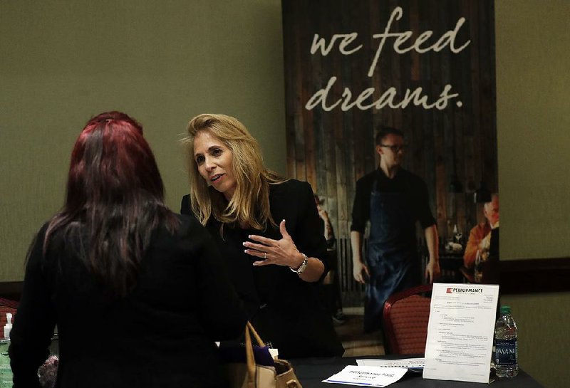 Grace Ochoa of Performance Food Service (right) talks with a job applicant at a career fair this week in Miami Lakes, Fla. U.S. hourly wages rose 2.9 percent last month and employers added 200,000 jobs, the government reported Friday.