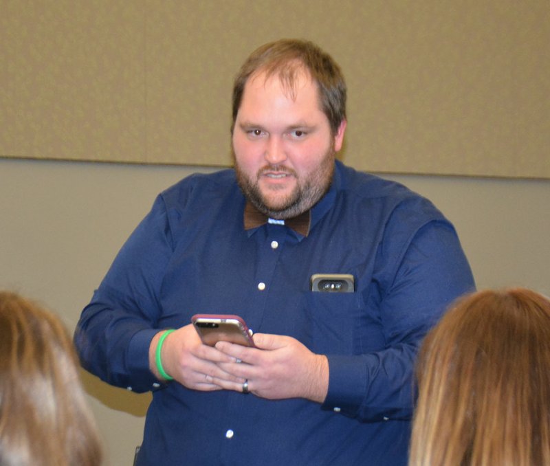 Mike Capshaw/Siloam Sunday Olin Rankin, a detective with the Benton County Sheriff's Office Cyber Crime Division, uses a member of the audience's cell phone to show how easy is it to find locations that the phone owner has frequented and various other data during a presentation at the Siloam Springs Library on Tuesday.