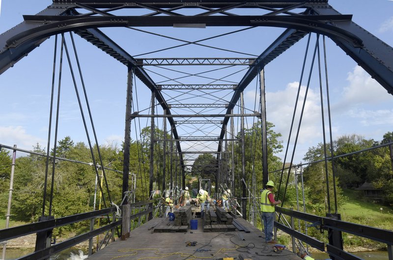 NWA Democrat-Gazette/FLIP PUTTHOFF Workers repair historic War Eagle bridge on Aug. 23. The bridge was closed May 2017 to September 2017. The historic bridge, built in 1907, carries traffic on Benton County Road 98 across the War Eagle River in southeast Benton County.
