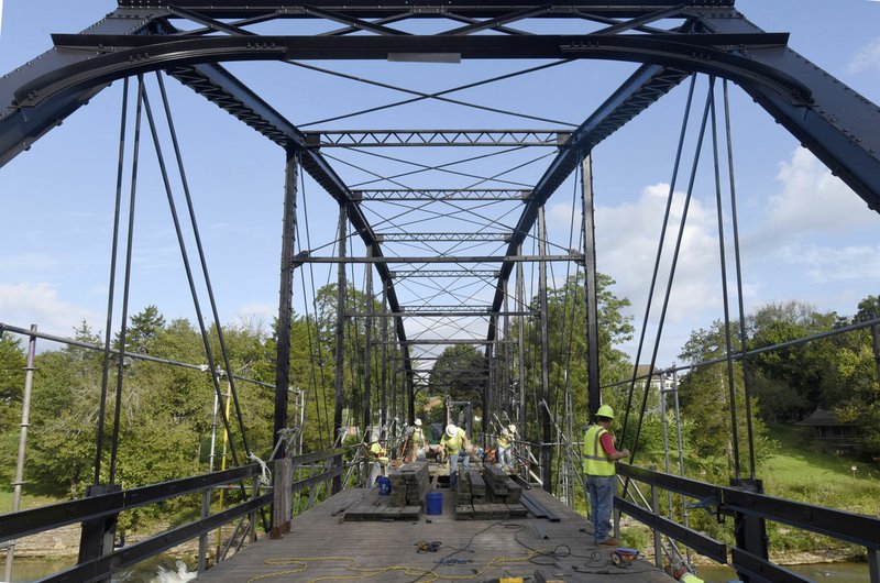 Workers make progress Wednesday Aug. 23 with repair work on the historic War Eagle bridge. The bridge is closed, but is on schedule to reopen around Sept. 30, said Jerry Heath, job superintendent with Crossland Heavy Contractors. The historic bridge, built in 1907, carries traffic on Benton County Road 98 across the War Eagle River in southeast Benton County.