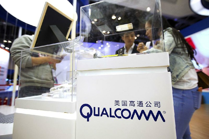 Visitors look at a display booth for Qualcomm at the Global Mobile Internet Conference in Beijing in April. Rival chipmaker Broadcom has increased its buyout offer for Qualcomm to more than $121 billion in what Broadcom calls its “best and final” offer.