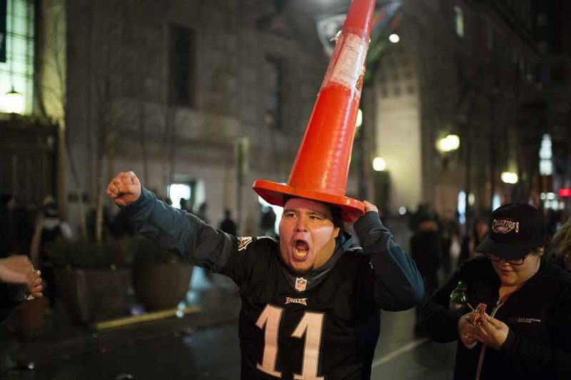 A Philadelphia Eagles fan marches with a cone on his head in downtown Philadelphia as fans celebrate the team's victory in the NFL Super Bowl 52 football game between the Eagles and the New England Patriots, in downtown Philadelphia Sunday, Feb. 4, 2018. (Camden Courier-Post via AP)