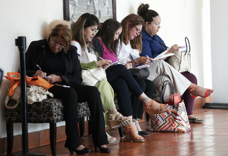 Women fill out job applications recently at a career fair in Miami Lakes, Fla. Job openings dropped 2.8 percent in December while the number of people leaving their jobs increased 3.1 percent, the U.S. Labor Department reported Tuesday.