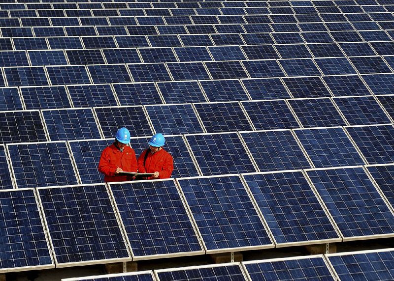 Workers check solar panels at a solar power station on a factory roof in Changxing in eastern China’s Zhejiang province in this 2012 photo. 