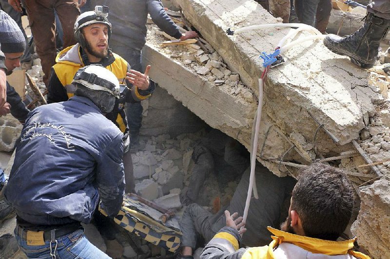 Civil defense workers search for survivors Monday after an airstrike in a rebel-held suburb of Damascus, Syria. The attacks by government and Russian forces continued Tuesday. 