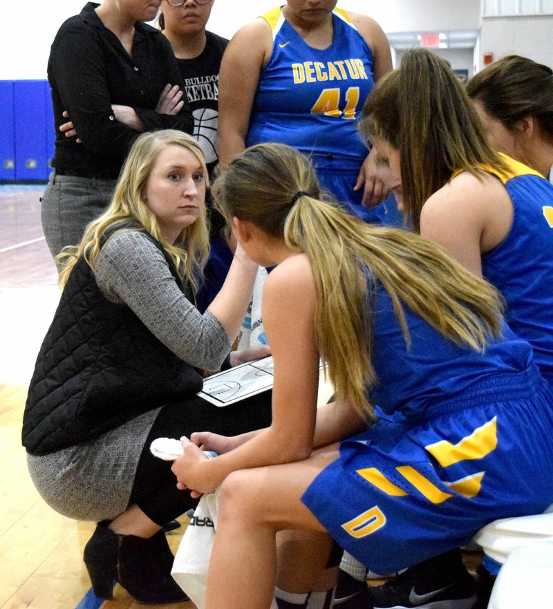 Westside Eagle Observer/MIKE ECKELS Ashley Riggles (center, left) talks to her senior girls' basketball team during a 30-second timeout during the Lady Hornets-Lady Bulldogs basketball contest at Hornet Arena in Colcord, Okla. Dec. 7, 2017.