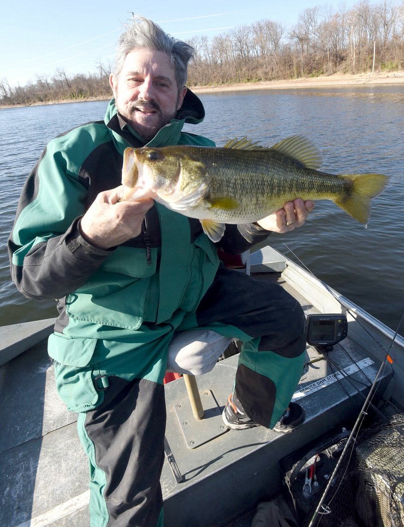 Westside Eagle Observer/FLIP PUTTHOFF Russ Tonkinson of Rogers shows a Swepco Lake largemouth bass he caught Dec. 13 2017 on a plastic worm. The 500-acre lake west of Gentry is a wintertime fishing destination because the water is warm all year.