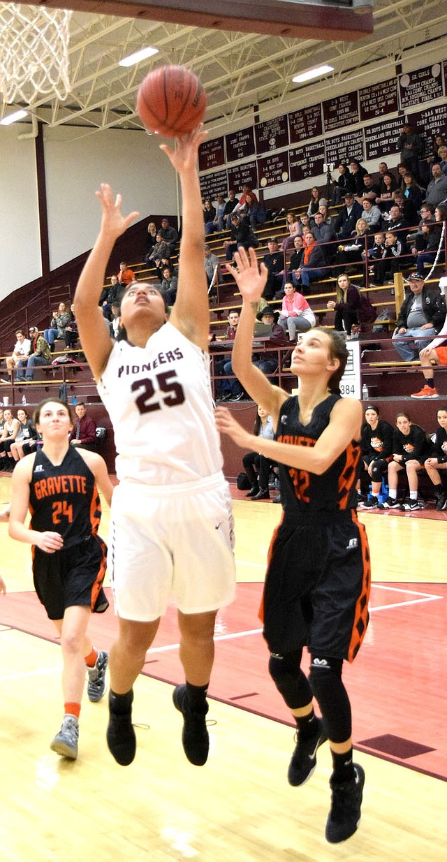 Westside Eagle Observer/MIKE ECKELS Chastery Fuamatu (Pioneers 25) attempts a layup from inside the lane while Tori Foster (Gravette 22) tries to block during the Lady Pioneers-Lady Lions basketball contest in Gentry Feb. 2.