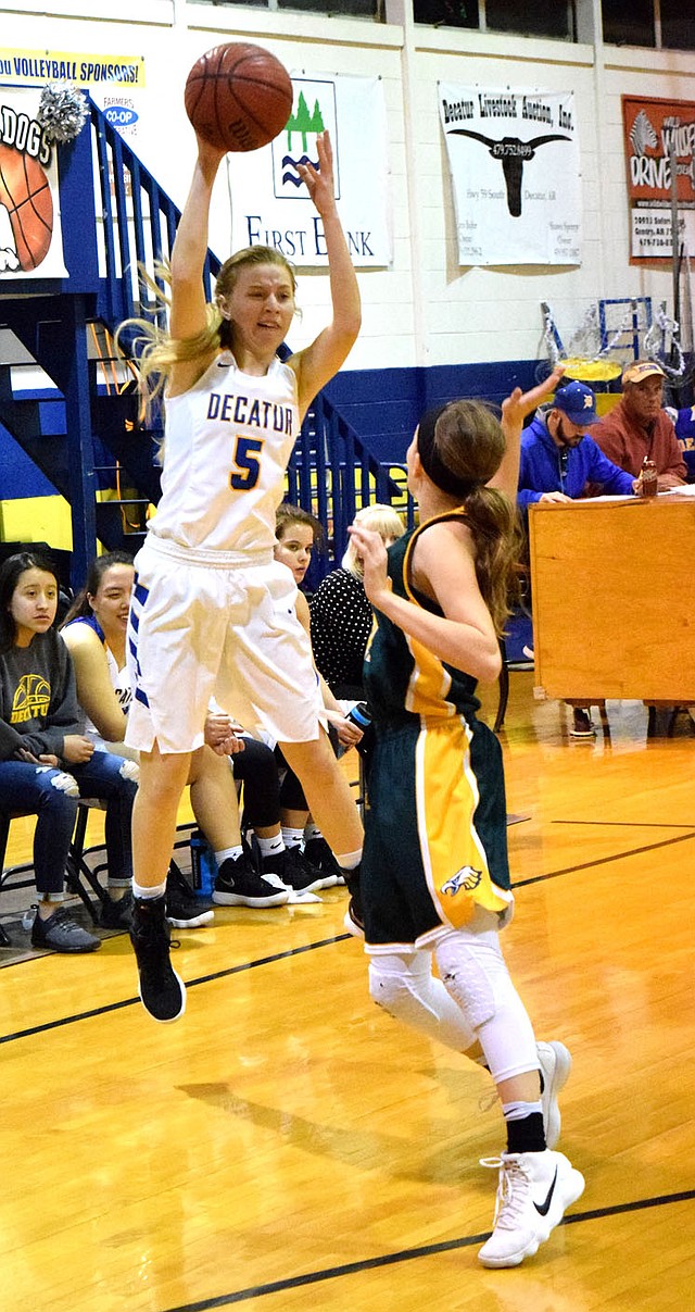 Westside Eagle Observer/MIKE ECKELS Paige Vann (Decatur 5) attempts a pass over the head of an Omaha player during the Lady Bulldogs-Lady Eagles basketball game at home in Decatur Jan. 30.