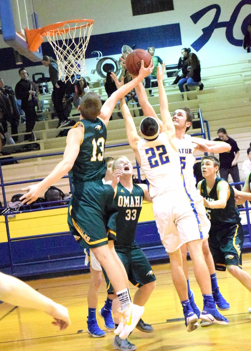 Westside Eagle Observer/MIKE ECKELS Garrett Matlock (Omaha 13) fights for an Eagle rebound with Decatur's Garry Wood (22) and Levi Newman (15, in front of Wood) during the Decatur-Omaha conference game at Peterson Gym in Decatur Jan. 30.