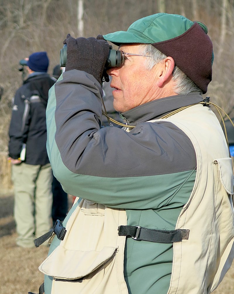 Westside Eagle Observer/RANDY MOLL Joe Neal, area bird expert, looks for wading birds in the mudflats along SWEPCO Lake on Saturday during a Northwest Arkansas Audubon Society fieldtrip to the Eagle Watch Nature Trail on Saturday morning (Feb. 3, 2018). About 40 people were out for the bird-watching event.