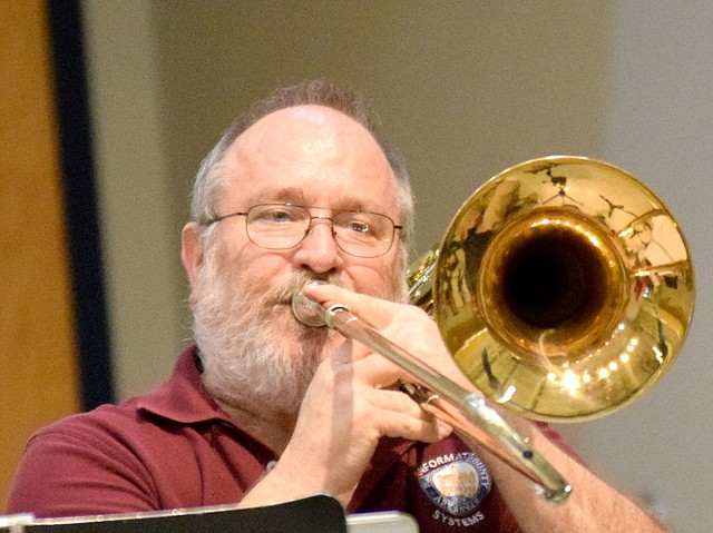 Bob Shaw, a member of the quintet Naturally Brass, demonstrates how the slide works on his trombone to students at Decatur Northside Elementary Jan. 22. Shaw and his fellow musicians were on hand to expose the young Decatur students to different types of instruments and musical styles.