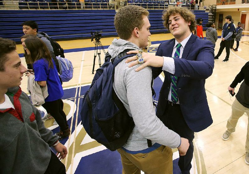 Pulaski Academy senior offensive lineman Luke Jones (right) greets junior tight end Hudson Henry after signing with Notre Dame on Wednesday. Jones originally committed to Arkansas before flipping to Notre Dame in December.