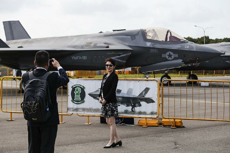 Visitors take a photo with a Lockheed Martin F-35B fighter jet parked at the static display area during the Singapore Airshow on Wednesday. More than 170 U.S. companies are represented at the show, using nearly a third of the exhibition space. 