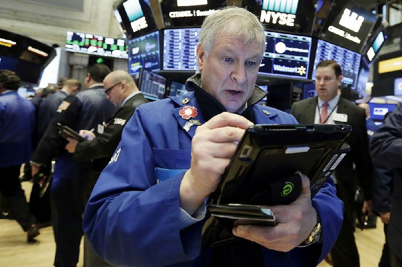 Trader Richard Newman works on the !oor of the New York Stock Exchange on Wednesday. Stocks closed down slightly on Wall Street as the market stabilized after three days of tumult. 