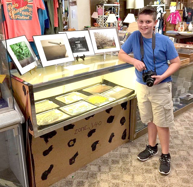 Courtesy photo Eleven-year-old Griffin Schutten showcases his talent at a local flea market vendor booth. The young entrepreneur and photographer has a real eye for capturing wildlife, flowers and an historical flooding event in Anderson.