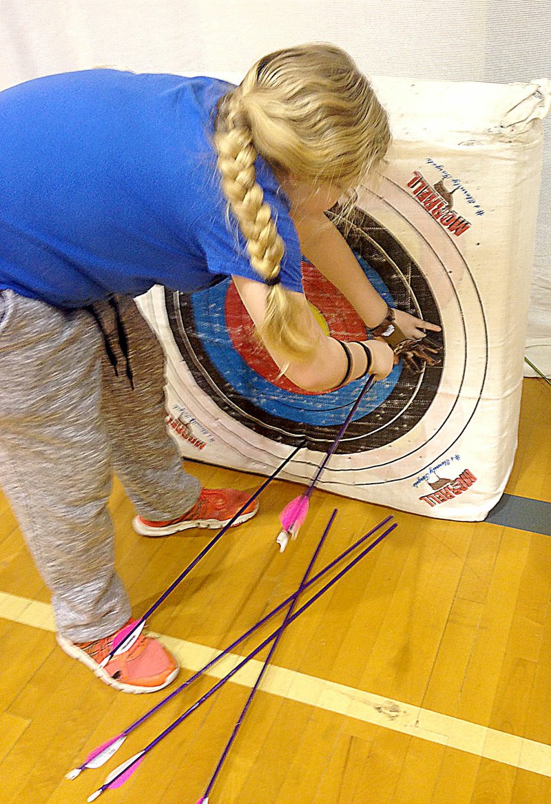 Photo by Sally Carroll Lillian Heithaus pulls her arrows out of the target at the end of practice. Students in grades five through eight meet after school at White Rock Elementary School twice a week to learn more about proper form and how to sharpen their shooting abilities in the White Rock Archery program.