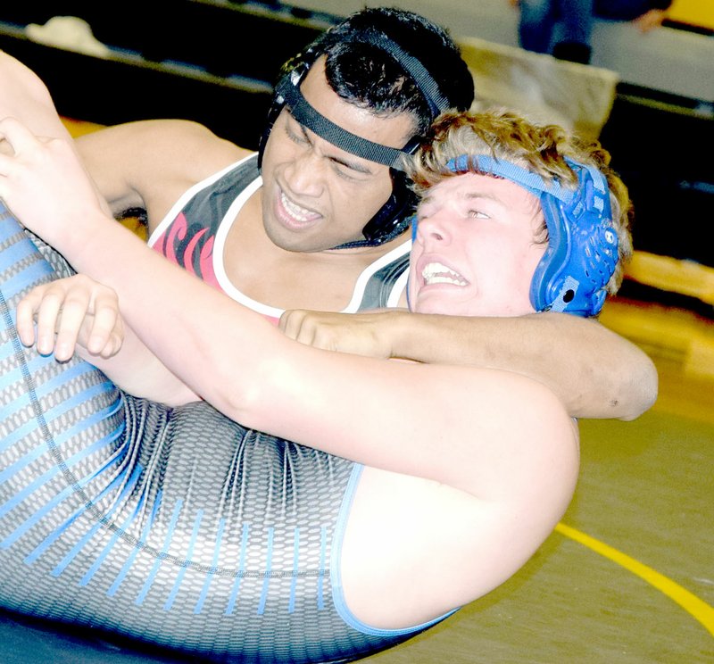 RICK PECK/SPECIAL TO MCDONALD COUNTY PRESS McDonald County's Wilson Menas strains as he nears a pin against Layne Brock of Hollister during the Mustangs, 54-25 win on Jan. 30 at Cassville High School.